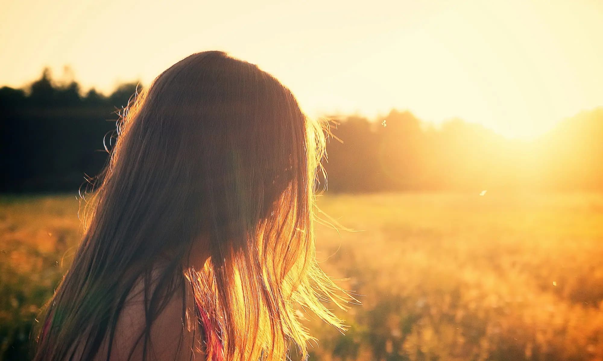 Woman looking toward the sunrise across a golden field — starting addiction treatment in Modesto, CA