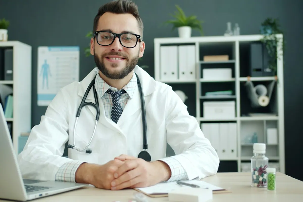Smiling physician at the desk of an outpatient addiction treatment clinic